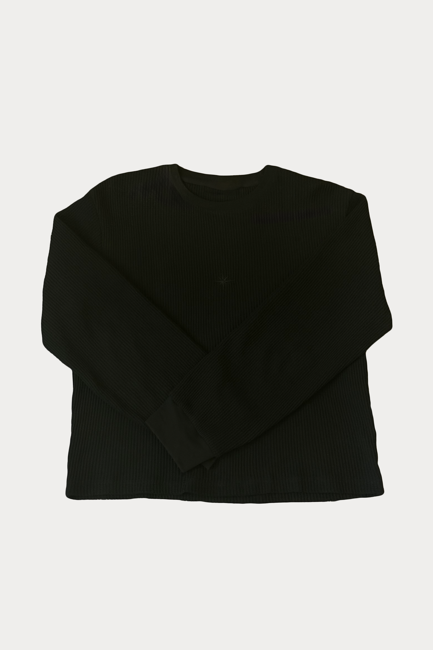 Front view of the La Cara Thermal Long Sleeve, a black organic cotton thermal shirt with subtle embroidered chest logo
