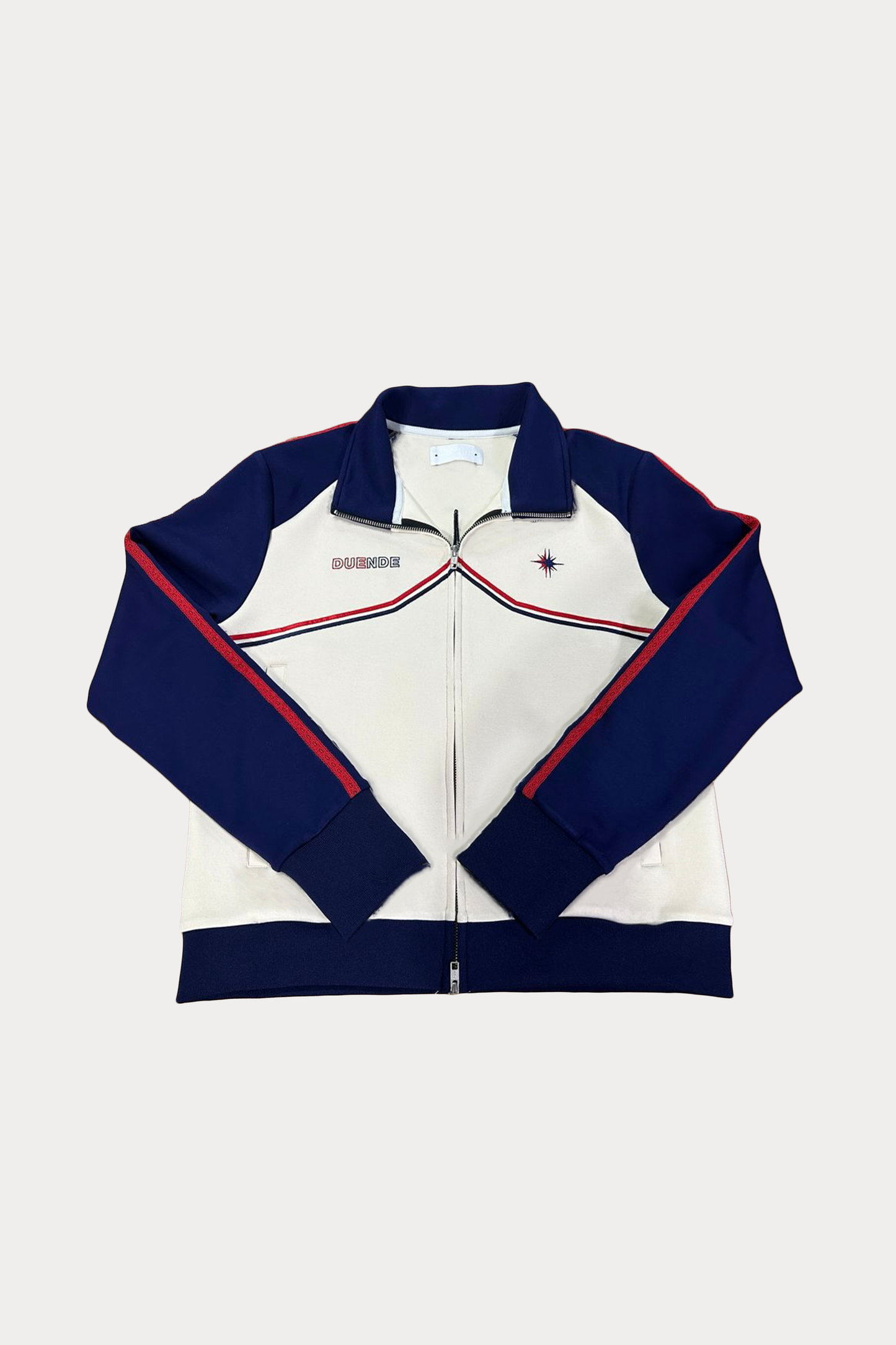 Vidrieras Track Jacket Front – premium track jacket and tracksuit jacket style design featuring navy sleeves, cream body, and embroidered DUENDE detailing, perfect as a modern jacket track silhouette
